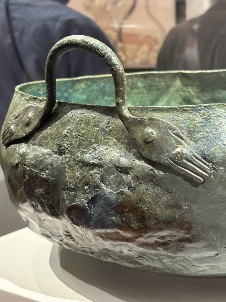 the handles of a bronze cauldron buried with the dead near the Palace of Nestor. Note the handles shaped like human hands. Photo by Regina Luz Jordan for Hollywoodland News.