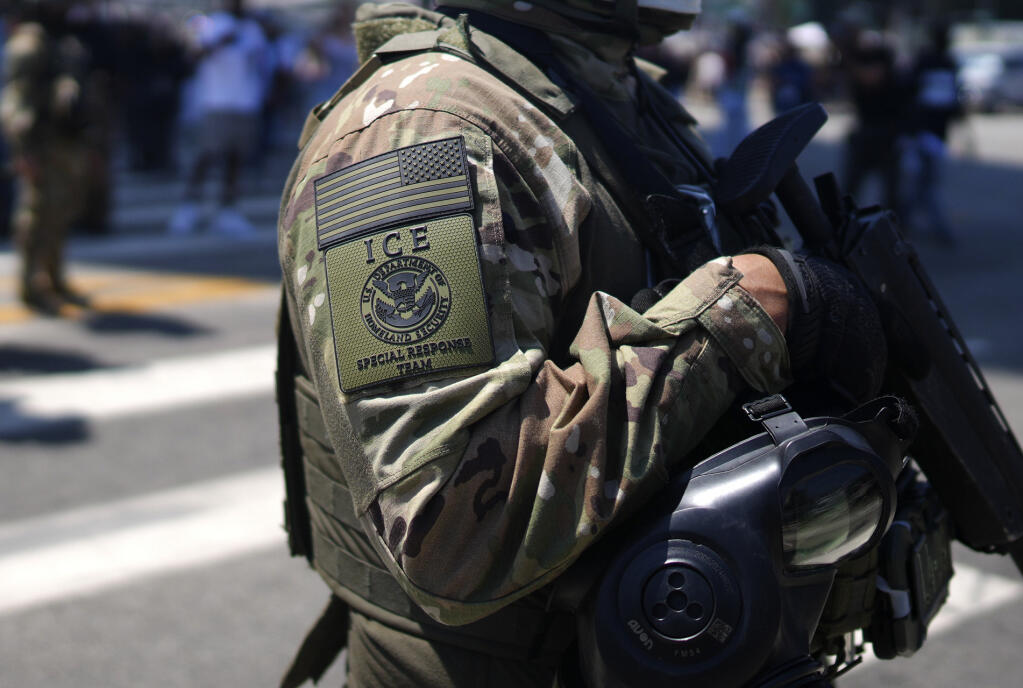An ICE Special Response Team member stands guard outside the Metropolitan Detention Center, while protesters gathered outside to denounce ICE operations, Tuesday, June 10, 2025, in downtown Los Angeles. (AP Photo/Eric Thayer)